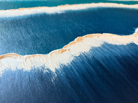 Close-up of a beach with waves and sand meeting the water.