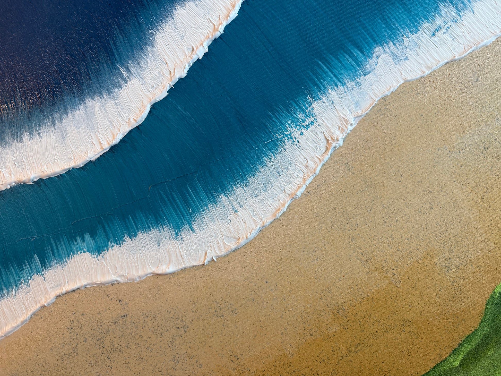 Top-down view of waves crashing onto a sandy beach