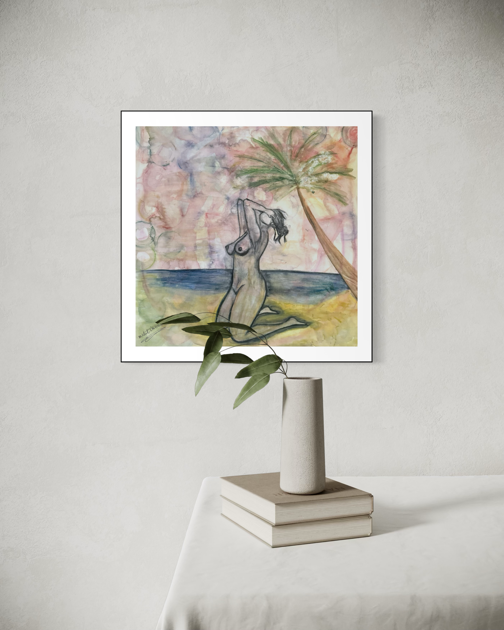 Framed artwork of a woman sitting by a beach with palm trees on a light gray wall.